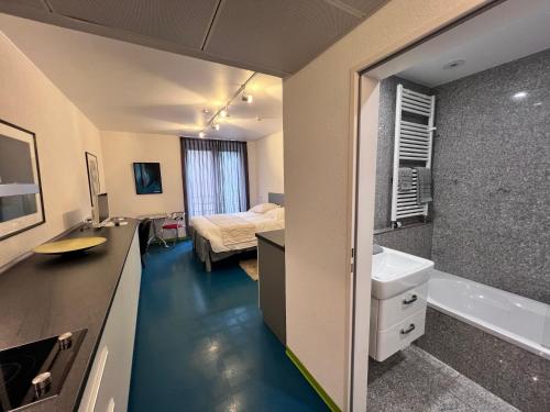 a room with a bathroom with a bed and a sink at Domus Hotel in Luxembourg