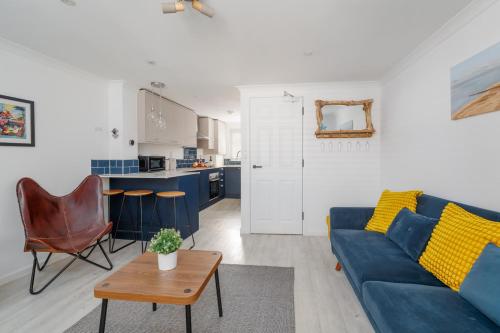 a living room with a blue couch and a table at Driftwood by Grandeur Property in Bournemouth