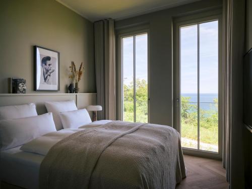 a bedroom with a bed and a large window at THE BALTIC VIEW Sellin in Ostseebad Sellin