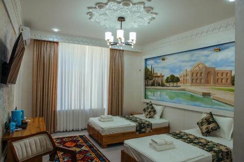 a hotel room with two beds and a painting on the wall at Aida hotel PREMIUM in Bukhara