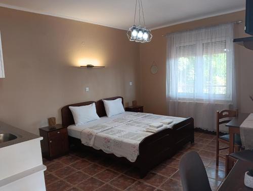 a bedroom with a bed in a room with a window at Ξενώνας Αντωνία in Kato Loutraki