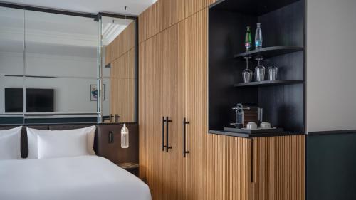 ein Schlafzimmer mit einem weißen Bett und Holzschränken in der Unterkunft Almanac X Alcron Prague in Prag