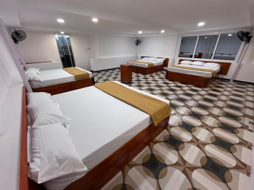 a room with three beds in a room at nkm cottage in Rāmeswaram