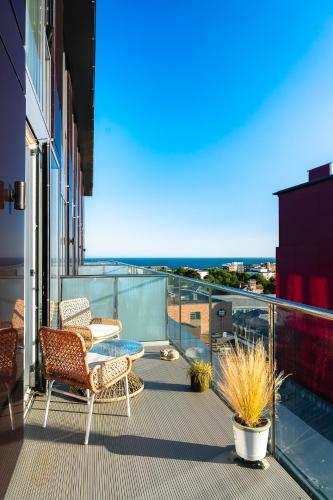 a balcony with chairs and a table on a building at Penthouse at the Chocolate Box in Bournemouth