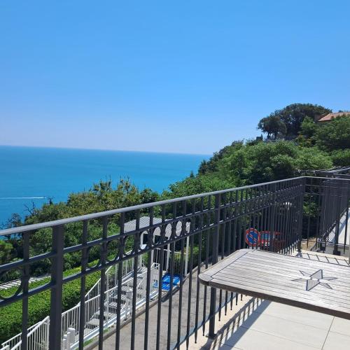 a balcony with a bench and the ocean in the background at Il Faro, Sirolo centro Vista Mare in Sirolo