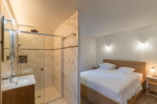 a bedroom with a shower and a bed and a sink at "Chez Jean" à Ruoms in Ruoms