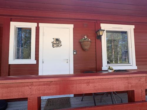 a front porch of a red house with two windows at Rena HOSTEL EINARA in Rena