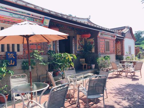 d'une terrasse avec des tables, des chaises et un parasol. dans l'établissement I-Shan B&B, à Jincheng