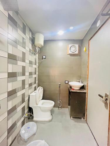 a bathroom with a toilet and a sink at Hotel Grand Plaza - Gate No 3 Dlf Chattarpur Farms in New Delhi