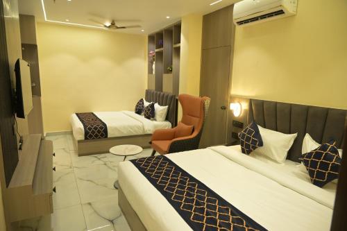 a hotel room with two beds and a chair at Hotel Bliss Kashi in Kakarmatha