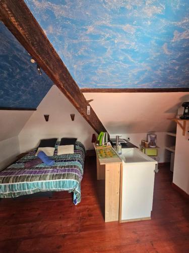 a bedroom with a bed and a blue ceiling at L'Irisée in Liévin