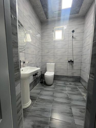 ein Badezimmer mit Toilette und Waschbecken in der Unterkunft Ромашка in Uçgün