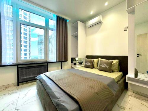 a bedroom with a large bed and a large window at Panoramic Plaza Apartments in Odesa
