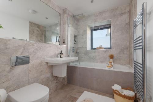 a bathroom with a sink and a tub and a toilet at Silvermere in Warmwell