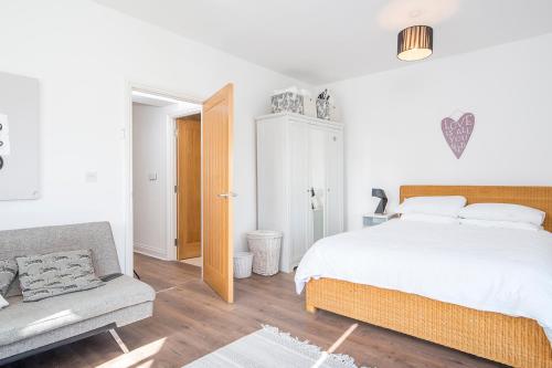 a white bedroom with a bed and a couch at Ramsey View in Solva