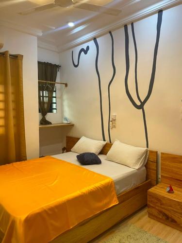 a bedroom with a bed with a painting on the wall at Smart Residences Apart Go in Cotonou