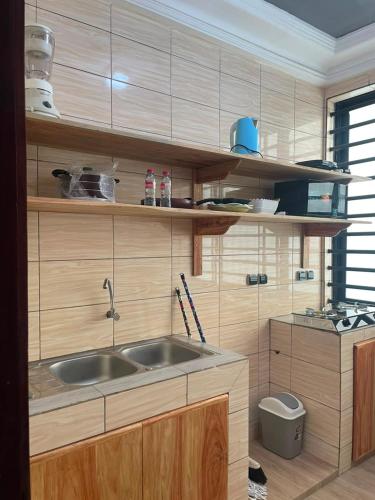 a kitchen with a sink and wooden cabinets at Smart Residences Apart Go in Cotonou