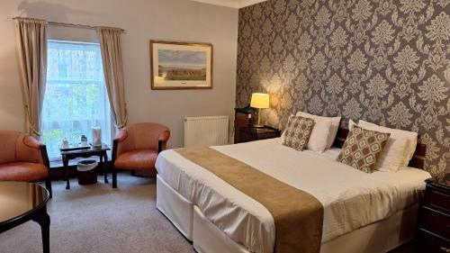 a hotel room with a bed and a window at Morangie Hotel Tain in Tain