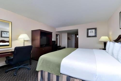 a hotel room with a large bed and a desk at Hermitage Hotel Richmond Virginia in Richmond