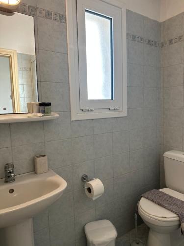 a bathroom with a sink and a toilet and a window at Elia I in Kondoliánika