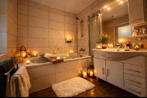 a bathroom with a tub and a sink and candles at Wellness Ferienhaus Garden in Michendorf