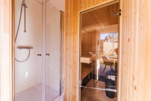 a glass shower door in a bathroom with a table at Dormio Resort Maastricht in Maastricht