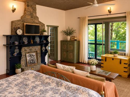 a living room with a fireplace and a couch at Kumaon Cottage, Nainital - AM Hotel Kollection in Nainital
