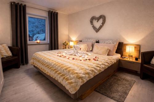 a bedroom with a large bed with a heart decoration on the wall at Wellness Ferienhaus Garden in Michendorf