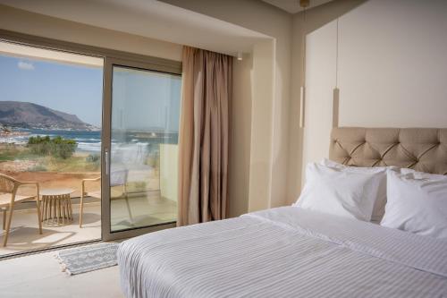 a bedroom with a bed and a view of the ocean at Akanthus Pirgos Bay in Malia