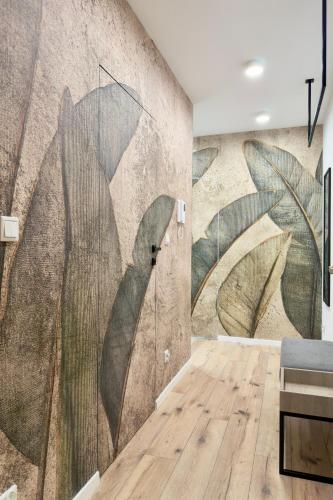 a room with a mural of leaves on the wall at Apartament Stara Fabryka 32 in Włocławek