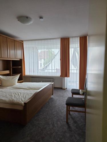 a hotel room with a bed and a chair at Haus Steinmeyer in Bad Pyrmont