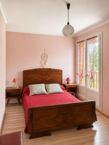 a bedroom with a large bed with red sheets and a window at Gîte Prat in Arette