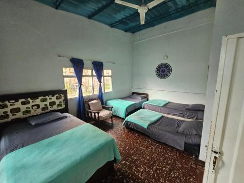 a bedroom with two beds and a chair and a window at VILLA ELSA in El Colegio