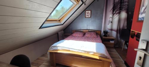 a small bedroom with a bed in a attic at Guim appart in Guimiliau