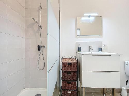 a white bathroom with a shower and a sink at Studio avec terrasse en rez de chaussée in Lapalme