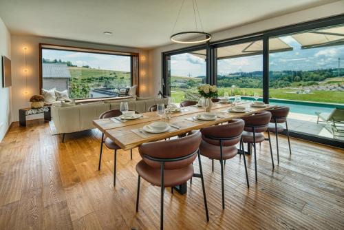a dining room with a large table and chairs at BlackForestChillOut - Pool - Garten - BBQ - Sauna in Stühlingen