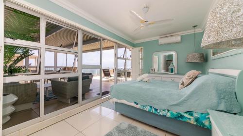a bedroom with a bed and a view of the ocean at 62 Camarque Umdloti Beachfront in Umdloti