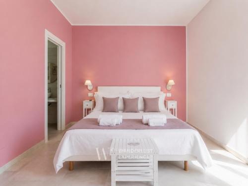 a bedroom with a large bed with pink walls at Wanderlust Experience Loggiato del duca in Bitonto