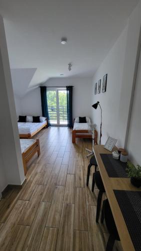 a living room with two beds and a wooden floor at Noclegi Na Gołębiówce in Wadowice