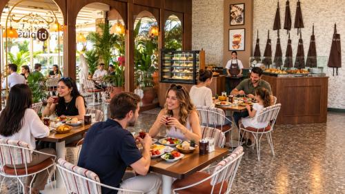 a group of people sitting at tables in a restaurant at New Inn Hotel Cadde 54 Mall in Sakarya