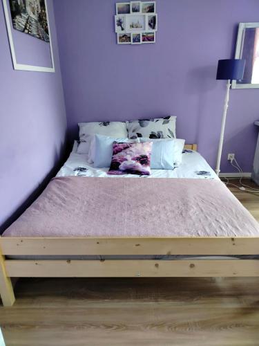 a bed with a wooden frame in a bedroom at Apartament Lawendowy in Wałbrzych