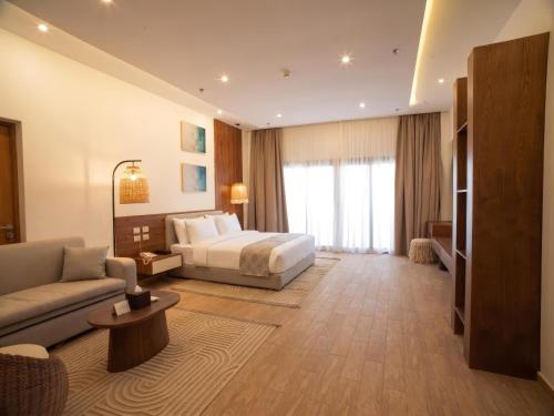 a hotel room with a bed and a couch at TIME Marina North Coast in El Alamein