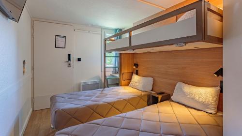 a bedroom with two beds and a loft bed at Premiere Classe Bayonne in Bayonne