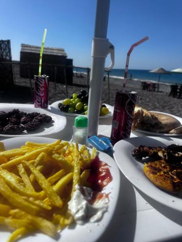 a table with plates of food and french fries at Chalets MB in Tarîfa
