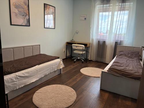 una camera da letto con due letti e una scrivania e una scrivania di Esterhazy Apartman a Galanta