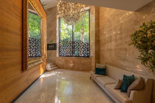 a hallway with a chandelier and a couch and windows at Hotel Constantine the Great in Belgrade