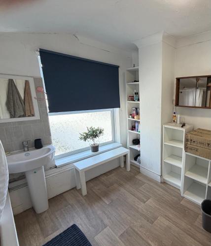 a bathroom with a sink and a window with a window blind at 86 Watling in Gillingham