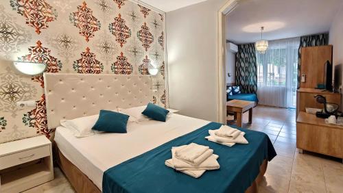 a bedroom with a bed with two towels on it at Family Hotel Sofi in Sozopol