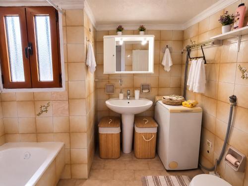 a bathroom with a sink and a toilet and a tub at Aposperitis in Amarynthos