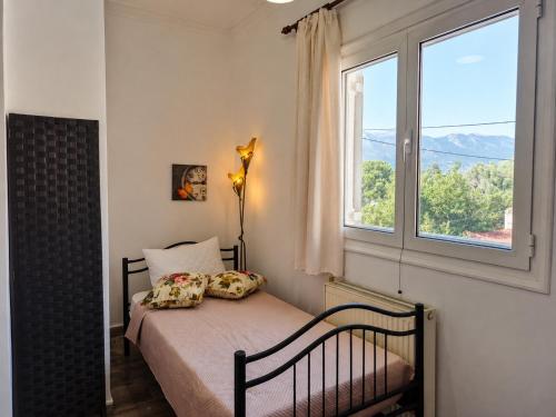 a bedroom with a bed and a window at Aposperitis in Amarynthos